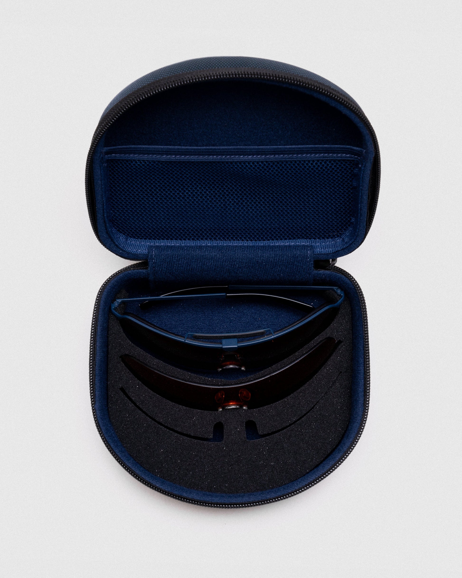 The Ranger Falcon Pro Shooting Sunglasses 3-Lens Kit features a protective navy nylon zippered case with custom foam inserts to securely store your frame and interchangeable shield lenses on the go.