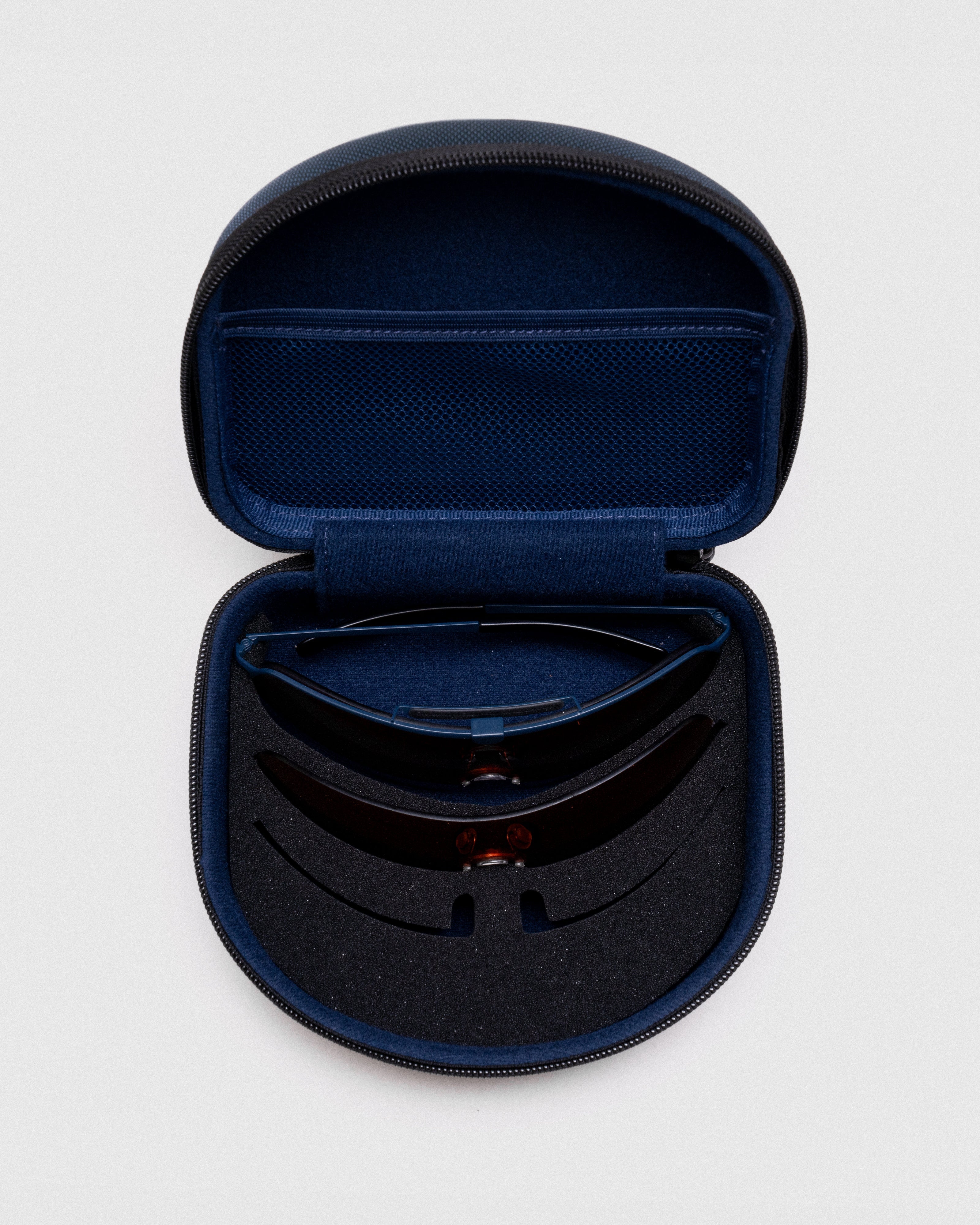 The Ranger Falcon Pro Shooting Sunglasses 3-Lens Kit features a protective navy nylon zippered case with custom foam inserts to securely store your frame and interchangeable shield lenses on the go.